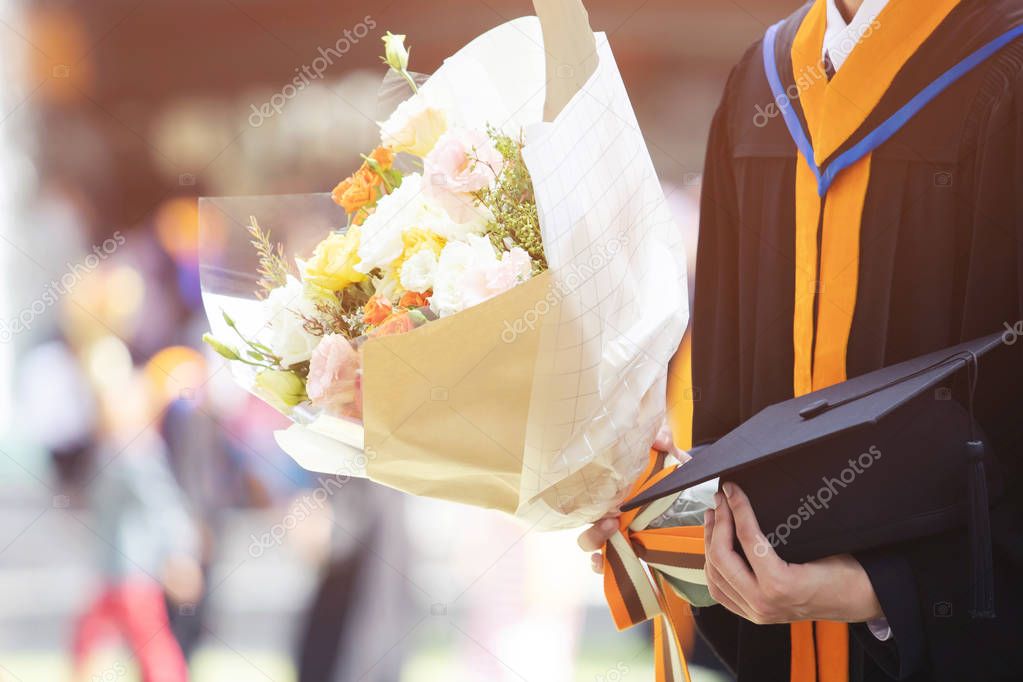 shot young female student in hand holding a bouquet of flowers the graduates of graduation hats during commencement success graduates of the university, Concept education congratulation.