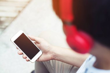 cep telefonu değişiklikleri şarkı ve parça için izole kopya alanı boş ekran ile müzik dinlemek için kulaklık kullanarak el akıllı telefon tutarak genç adam. kulaklık ritim zevk. teknoloji kavramı