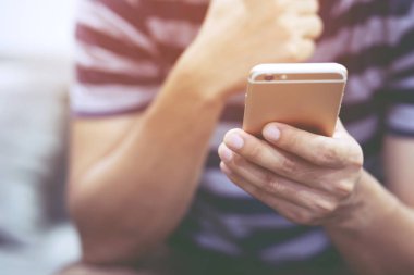 insanlar Casual koltuk sırasında cep telefonu kullanarak giymek. cep telefonu mesajı izlerken oturan baş ağrısı kötü bir haber almak varken belirtileri üzücü mutsuz genç adam alnını tutan
