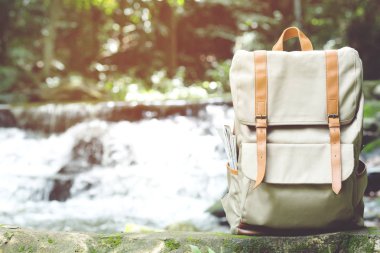Hipster Sırt Çantası orman Seyahat aksesuarları ve Ahşap kereste günlük harita yürümek. Arka plan Orman ağacında arka turist gezgin çanta görünümü. konsept tatil Seyahat.