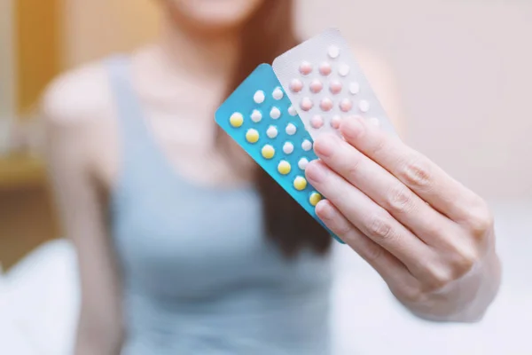 女性は手に避妊薬を開く手 避妊薬を食べる — ストック写真