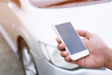 bir cep telefonu akıllı telefon arama kullanarak erkek el yakın bir araba tamircisi yardım isteyin çünkü araba yol kenarında kırık. boş ekranın boş.