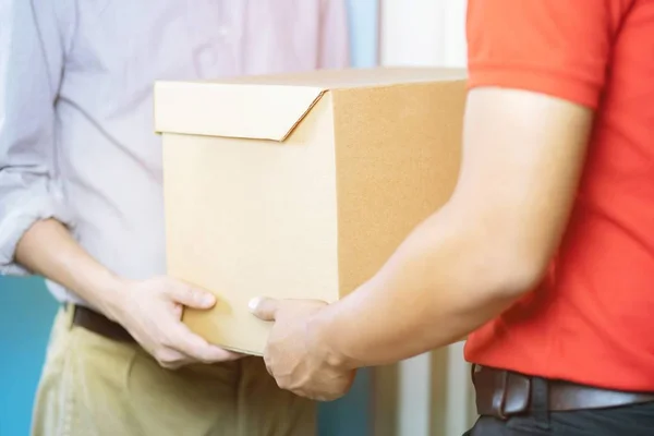 包裹递送人通过服务包裹 并关闭手客户接受从送货人邮寄直接送货到家的箱子 — 图库照片