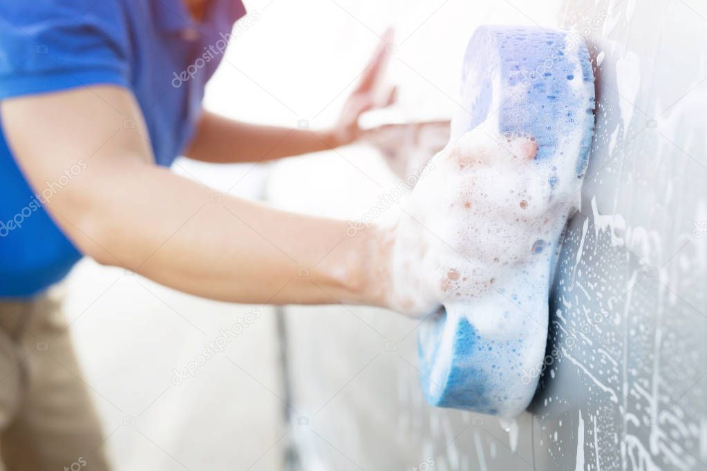 people man worker holding hand blue sponge for washing car. Concept car wash clean. soft focus.