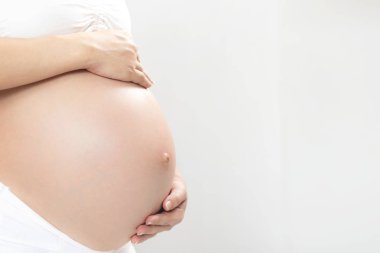 Beyaz iç çamaşırı yeni anne Hamile kadın bebek ile el dokunmatik karın göbeği kullanır. Bebek bekleyen genç kadın açık havada durun.