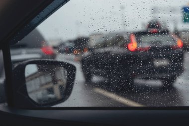 Gece camına yağmur damlaları. şiddetli yağmurda sokak. Bokeh Kuyruk ışığı. yumuşak Odak. Lütfen dikkatli sür, kaygan yoldan. yumuşak odak. trafik sıkışıklığı araba.