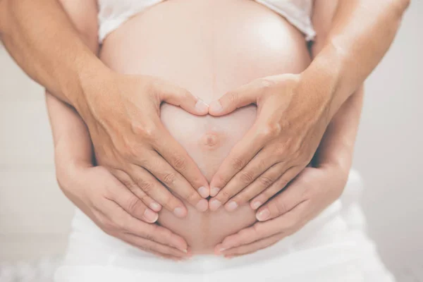 Zwangere Vrouw Haar Man Hand Splice Knuffelen Buik Hartvormige Toon — Stockfoto