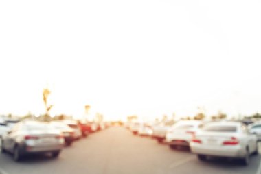 Fotoğraf bulanık hava otoparkı açık hava meydanı, sıra sıra park edilmiş arabalar yol kenarında ve akşam güneşinde. Metin için boşluk bırak.