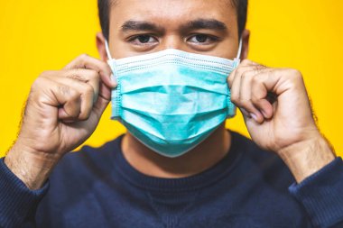 Adam Corona virüsünden korunmak için maske takıyor.