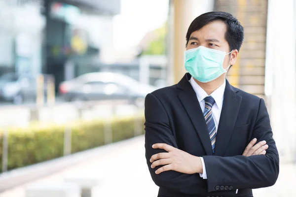 サラリーマンはオフィスに行く前にコロナウイルスを保護するためのマスクをしています — ストック写真