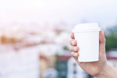 İzole edilmiş kahve bardağını tutan erkek eli. 