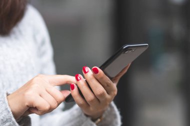 Kadınlar alışveriş merkezlerinde cep telefonu kullanıyor.