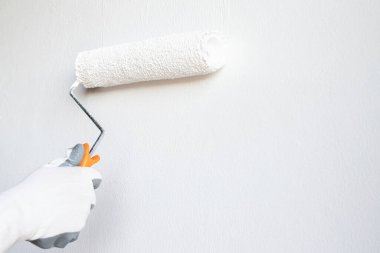 Ressam evdeki yatak odasının duvarına beyaz bir temel çiziyor..