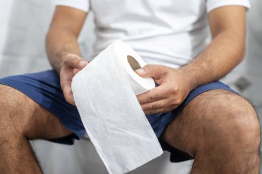 Banyoda midesi ağrıyan bir adam.