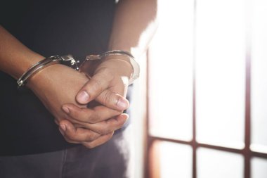 Tutsağın eli çelik bir kafesin üzerinde 