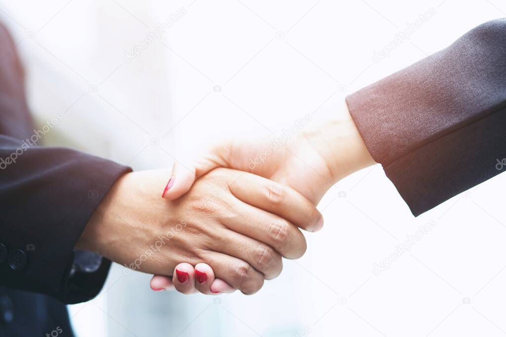 businessman shaking hands with businesswoman after UI UX desiner meeting.