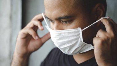 COVID 19 'u önlemek için maske takan bir adam.