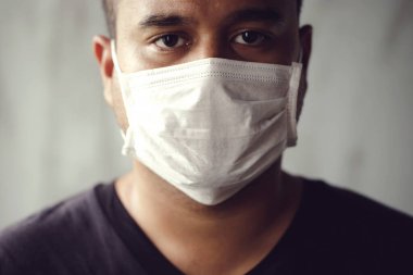 Coronavirüs salgınını önlemek için maske takan yeni Normarl adam.