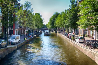 Amsterdam, Hollanda - 08 Temmuz 2018: Yaz aylarında teknelerle Canal. Eski Amsterdam tarihi evlerde. Tipik Hollanda Mimarlık.