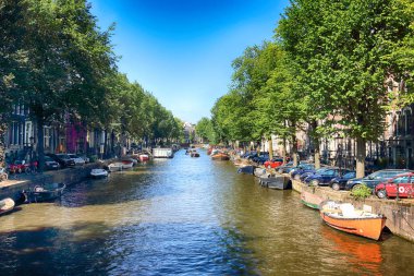 Amsterdam, Hollanda - 08 Temmuz 2018: Yaz aylarında teknelerle Canal. Eski Amsterdam tarihi evlerde. Tipik Hollanda Mimarlık.