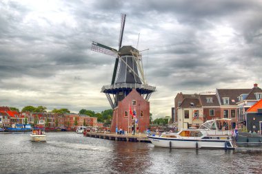 Haarlem, Hollanda - 09 Temmuz 2018: Yel değirmeni Adriaan ile Spaarne nehir ve güzel bulutlar. Tipik Hollanda Mimarlık.