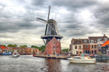 Haarlem, Hollanda - 09 Temmuz 2018: Yel değirmeni Adriaan ile Spaarne nehir ve güzel bulutlar. Tipik Hollanda Mimarlık.