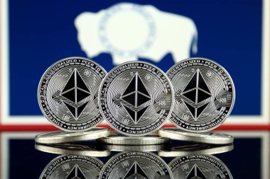 Ethereum (Eth) ve Wyoming devlet bayrağı fiziksel sürümü. Blockchain teknolojisi, akıllı sözleşmeler, kişisel belirteçleri ve ilk para sunan cryptocurrency, yatırımcılar için kavramsal görüntü.