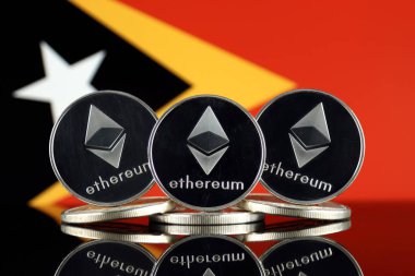 Ethereum (Eth) ve Doğu Timor bayrağı fiziksel sürümü. Blockchain teknolojisi, akıllı sözleşmeler, kişisel belirteçleri ve ilk para sunan cryptocurrency, yatırımcılar için kavramsal görüntü.