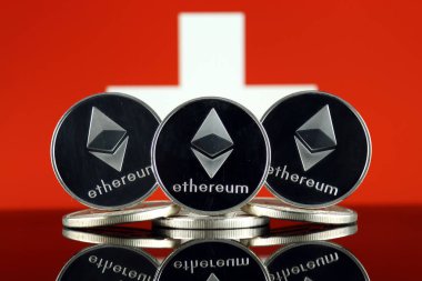 Ethereum (Eth) ve İsviçre bayrağı fiziksel sürümü. Blockchain teknolojisi, akıllı sözleşmeler, kişisel belirteçleri ve ilk para sunan cryptocurrency, yatırımcılar için kavramsal görüntü.