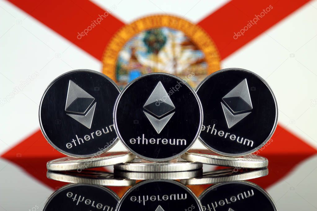Physical version of Ethereum (ETH) and Florida State Flag. Conceptual image for investors in cryptocurrency, Blockchain Technology, Smart Contracts, Personal Tokens and Initial Coin Offering.