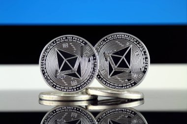 Ethereum (Eth) ve Estonya bayrağı fiziksel sürümü. Blockchain teknolojisi, akıllı sözleşmeler, kişisel belirteçleri ve ilk para sunan cryptocurrency, yatırımcılar için kavramsal görüntü.