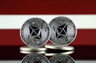 Ethereum (Eth) ve Letonya bayrağı fiziksel sürümü. Blockchain teknolojisi, akıllı sözleşmeler, kişisel belirteçleri ve ilk para sunan cryptocurrency, yatırımcılar için kavramsal görüntü.
