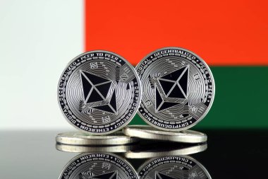 Ethereum (Eth) ve Madagaskar bayrağı fiziksel sürümü. Blockchain teknolojisi, akıllı sözleşmeler, kişisel belirteçleri ve ilk para sunan cryptocurrency, yatırımcılar için kavramsal görüntü.