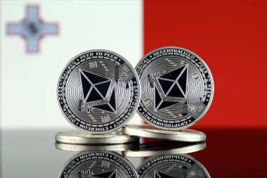 Ethereum (Eth) ve Malta bayrağı fiziksel sürümü. Blockchain teknolojisi, akıllı sözleşmeler, kişisel belirteçleri ve ilk para sunan cryptocurrency, yatırımcılar için kavramsal görüntü.