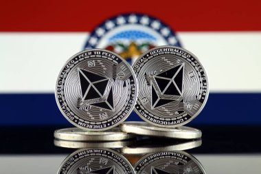 Ethereum (Eth) ve Missouri devlet bayrağı fiziksel sürümü. Blockchain teknolojisi, akıllı sözleşmeler, kişisel belirteçleri ve ilk para sunan cryptocurrency, yatırımcılar için kavramsal görüntü.