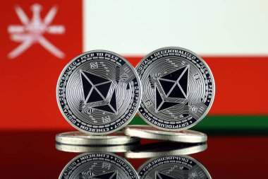 Ethereum (Eth) ve Umman bayrağı fiziksel sürümü. Blockchain teknolojisi, akıllı sözleşmeler, kişisel belirteçleri ve ilk para sunan cryptocurrency, yatırımcılar için kavramsal görüntü.