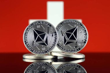 Ethereum (Eth) ve İsviçre bayrağı fiziksel sürümü. Blockchain teknolojisi, akıllı sözleşmeler, kişisel belirteçleri ve ilk para sunan cryptocurrency, yatırımcılar için kavramsal görüntü.