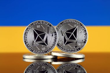 Ethereum (Eth) ve Ukrayna bayrağı fiziksel sürümü. Blockchain teknolojisi, akıllı sözleşmeler, kişisel belirteçleri ve ilk para sunan cryptocurrency, yatırımcılar için kavramsal görüntü.
