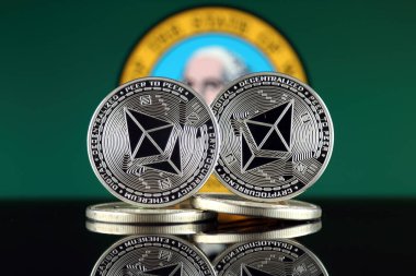Ethereum (Eth) ve Washington Devlet bayrağı fiziksel sürümü. Blockchain teknolojisi, akıllı sözleşmeler, kişisel belirteçleri ve ilk para sunan cryptocurrency, yatırımcılar için kavramsal görüntü.
