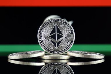 Ethereum (Eth) ve Libya bayrağı fiziksel sürümü. Blockchain teknolojisi, akıllı sözleşmeler, kişisel belirteçleri ve ilk para sunan cryptocurrency, yatırımcılar için kavramsal görüntü.