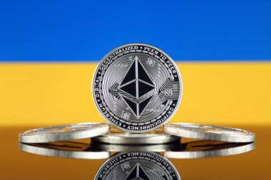 Ethereum (Eth) ve Ukrayna bayrağı fiziksel sürümü. Blockchain teknolojisi, akıllı sözleşmeler, kişisel belirteçleri ve ilk para sunan cryptocurrency, yatırımcılar için kavramsal görüntü.