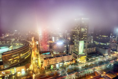 Varşova, Polonya - 4 Kasım 2018: Varşova, Polonya'nın şehir merkezi bölgesinde Modern gökdelenler. Sisli gece boyunca havadan görünümü.