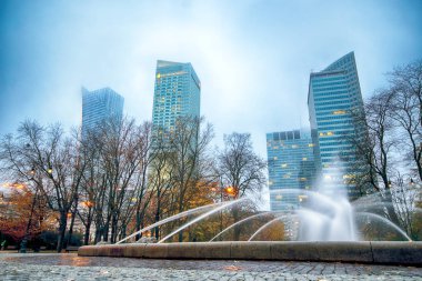 Varşova, Polonya - 3 Kasım 2018: Varşova, Polonya'nın şehir merkezi bölgesinde Modern gökdelenler. Sisli gece boyunca sokak düzeyinde bir görünüm.