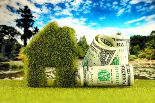 One dollar banknotes and green eco house icon concept with grass and blue sky background. Renewable energy. Electricity prices, energy saving in the household.