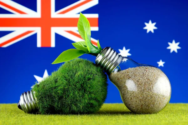 Green eco light bulb with grass, plant growing inside the light bulb, and Australia Flag. Renewable energy. Electricity prices, energy saving in the household.