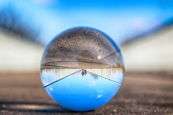 Long bridge in Wroclaw, Poland. View through a glass, crystal ball (lensball) for refraction photography.