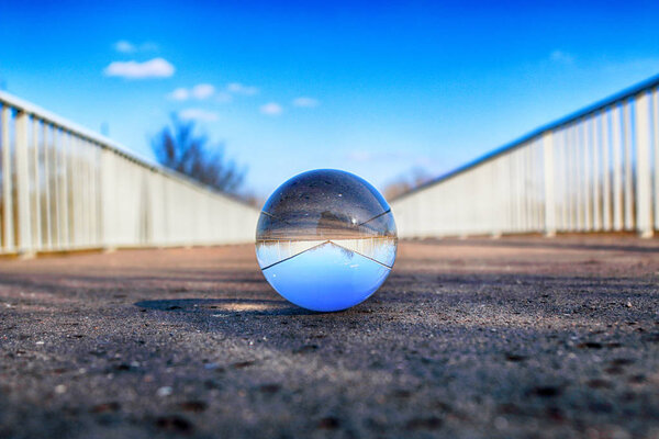 Long bridge in Wroclaw, Poland. View through a glass, crystal ball (lensball) for refraction photography.