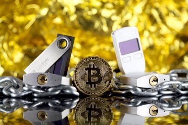 Wroclaw, Polonya - 06 Temmuz 2019: Bitcoin (Btc), Trezor ve Ledger (kripto para donanım cüzdanları), gümüş asma kilitler ve zincirin fiziksel sürümü (Blockchain Technology gibi). Stüdyo çekimi.
