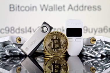 Wroclaw, Polonya - 06 Temmuz 2019: Bitcoin (Btc), Trezor ve Ledger (kripto para donanım cüzdanları), gümüş asma kilitler ve zincirin fiziksel sürümü (Blockchain Technology gibi). Stüdyo çekimi.