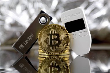 Wroclaw, Polonya - 06 Temmuz 2019: Bitcoin (Btc), Trezor ve Ledger'ın fiziksel sürümü (kripto para birimi donanım cüzdanları). Stüdyo çekimi.